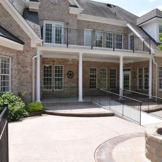 A two-story brick house with a balcony and ramp access.