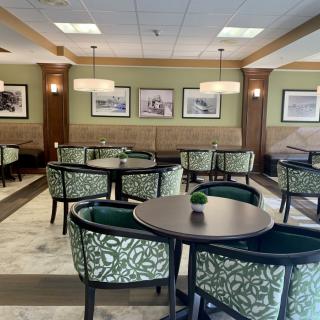 A stylish and cozy dining area with neatly arranged tables and chairs.