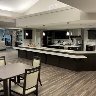 A modern kitchen and dining area with sleek furnishings and lighting.