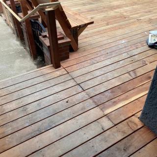 A wooden deck with stairs leading off, showcasing outdoor construction.