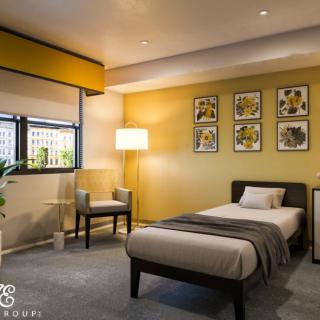 A modern and cozy bedroom with a single bed, featuring yellow walls and contemporary wall art.