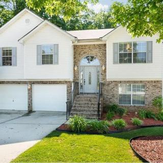 A charming two-story suburban house with well-maintained landscaping.