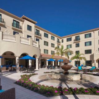 A luxurious hotel courtyard featuring a central fountain and surrounded by elegant architecture.
