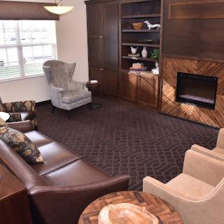 A cozy and elegantly designed living room featuring comfortable seating, wooden accents, and a fireplace.