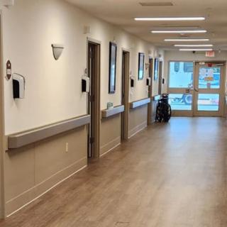 A clean and empty hospital hallway with several doors leading to medical rooms.