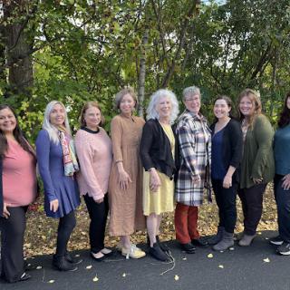 A group of women enjoying a beautiful day outdoors, standing together in a picturesque setting.