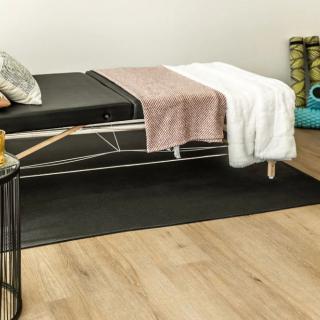 A serene therapy room featuring a massage table with cozy blankets and pillows.
