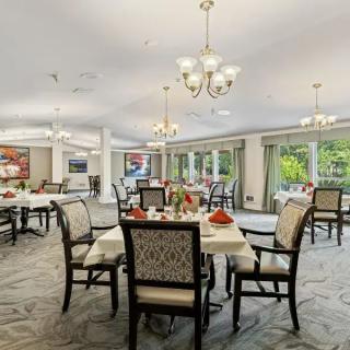 Elegant dining area with neatly arranged tables and comfortable chairs, highlighted by warm chandeliers.