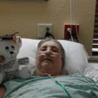 A patient in a hospital bed with a stuffed animal by their side.