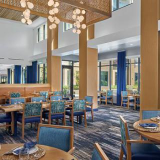 An elegant restaurant interior featuring blue chairs and modern lighting.