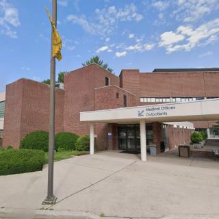 The entrance to a brick healthcare building on a sunny day.