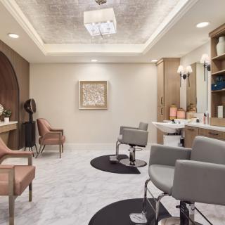 A modern salon interior with stylish chairs and elegant lighting.