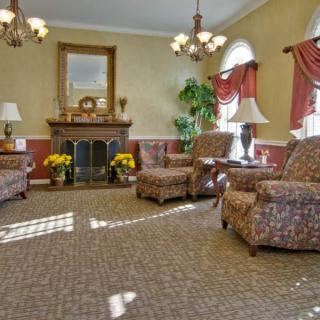 A traditional living room featuring a fireplace, armchairs, and elegant decor.