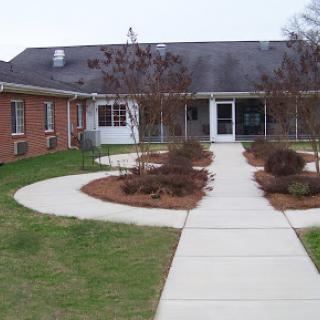 A welcoming entrance to a building surrounded by landscaped gardens.