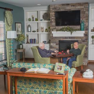 Two people engaged in a conversation in a cozy living room setting.