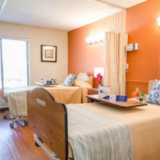 A well-maintained hospital room with two patient beds, showcasing a comfortable and clean environment.