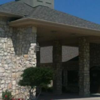 A stone building with a covered entrance and a gray roof.