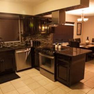 A modern kitchen with stainless steel appliances and a nearby dining area.