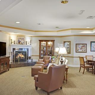 A cozy living room with a seating area arranged around a fireplace.