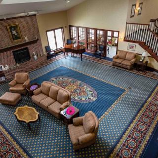 Spacious living room with comfortable seating, a grand piano, and elegant decor.