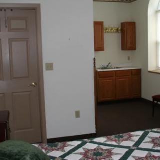 A cozy hotel room with a bed and a small kitchenette.
