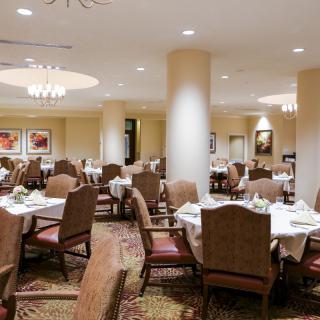 An elegant restaurant dining room with neatly arranged tables and chairs, ready for guests.