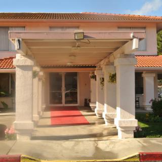 A grand entrance of a building with columns and a red carpet.