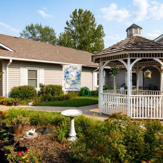 A charming outdoor scene featuring a house with a garden and a gazebo.