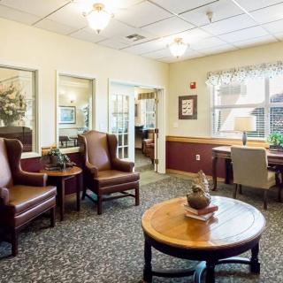 A cozy living area featuring comfortable chairs, a round table, and tasteful decor.