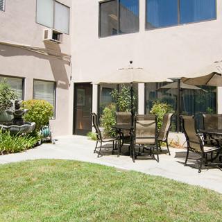 A cozy backyard patio with outdoor furniture and a well-maintained lawn.