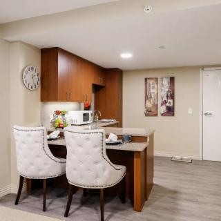 A modern kitchen and dining area with a wooden countertop, barstools, and stylish decor.