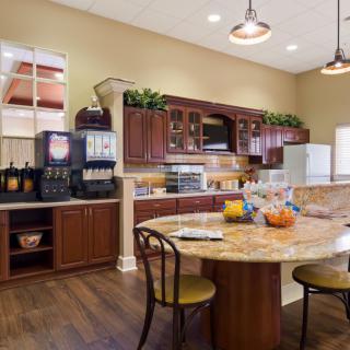 Spacious kitchen area with wooden cabinets and a large dining table.