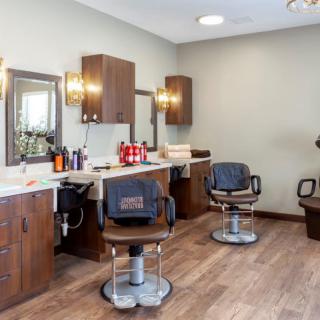 An interior view of a barbershop with styling chairs and mirrors.