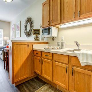 A cozy kitchen with wooden cabinets and a countertop, featuring a sink and microwave.