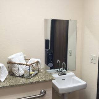 A clean and minimalist bathroom setup featuring a sink, mirror, and neatly arranged towels.