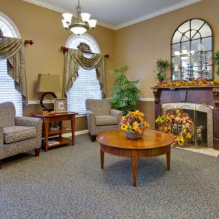 A cozy and elegantly decorated living room with armchairs, a coffee table, and a fireplace.