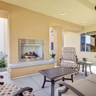 A cozy outdoor patio with comfortable seating and a built-in fireplace.