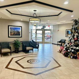 A welcoming lobby decorated for the holiday season, featuring a beautifully adorned Christmas tree and comfortable seating.