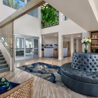 A modern lobby area featuring elegant furniture and a stylish staircase.