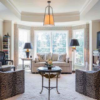 A well-lit living room featuring elegant furniture and large windows.