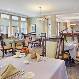 A formal dining room with neatly arranged tables and chairs, showcasing an elegant interior design.