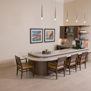 A modern kitchen dining area featuring a sleek countertop, stylish chairs, and decorative artwork.