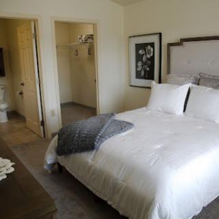 A cozy and minimalistic bedroom featuring a neatly made bed and soft decor.