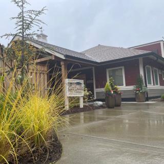 A modern house with a landscaped front yard and an overcast sky.