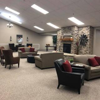 A spacious living room with comfortable seating and a stone fireplace.
