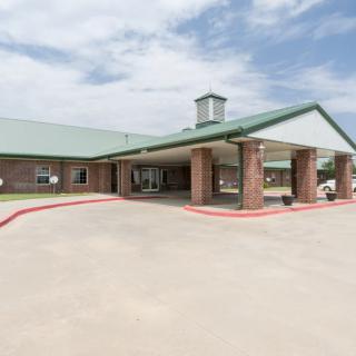 A brick building with a covered entrance and clear skies above.