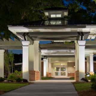 A beautifully lit entrance to a modern building at dusk.