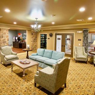 A cozy living room with comfortable seating, a chandelier, and warm lighting.