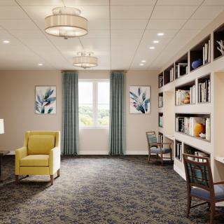 A cozy living room with bookshelves and a reading area.
