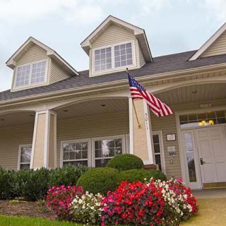 A suburban house with an American flag and a well-maintained garden.